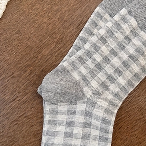 Detailed view of gray and white plaid knit socks showing the reinforced heel structure