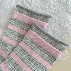 Close-up of pink and grey striped knitted socks with rolled edge ribbing detail