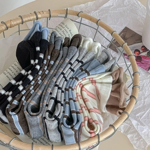 Close-up of assorted striped knit cotton socks arranged in a vintage wire gift basket