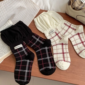 Detail of vintage plaid crew socks featuring elastic ruffled cuffs and brand fabric labels