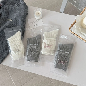 Detail of four pairs of ballet-style ribbon socks in cream and grey knit fabric