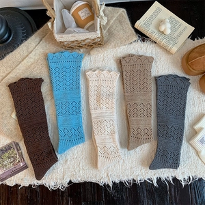 Detail of five colored hollow knit long socks with wavy patterns and scalloped edges