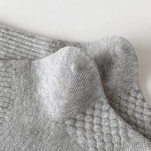 Detail shot of grey crew socks featuring breathable mesh knit and ribbed cuff texture