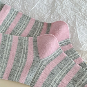 Detail of pink and grey striped knitted socks with fine ribbing and soft cotton texture
