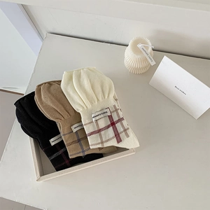 Detailed view of plaid cotton crew socks with wavy ruffled cuffs and brand label on tray