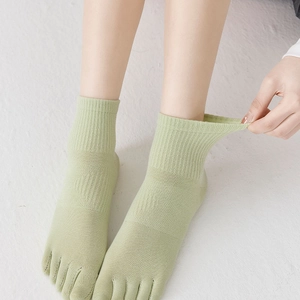 Close-up of elastic cuff on light green five-finger socks in breathable cotton knit