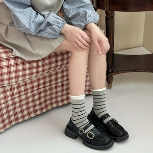 Retro grau gestreifte Socken mit schwarzen Mary Janes für einen klassischen Vintage-Stil