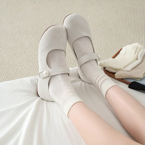 Detail of cream Mary Jane shoes with pearl buckle and matching white cotton socks
