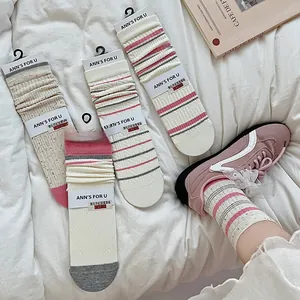 Dettaglio di calze a righe dolci con jacquard a fiocco 3D su tessuto bianco