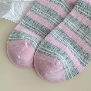 Detailed close-up of pink and grey striped knit cotton socks with reinforced toe stitching