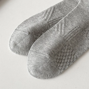 Macro detail of reinforced grey cotton sock toe area showing fine knit texture and craftsmanship