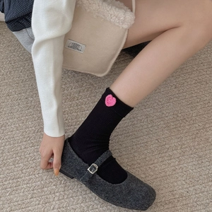 Ribbed mid-calf black socks with pink knitted heart charm styled with Mary Jane shoes