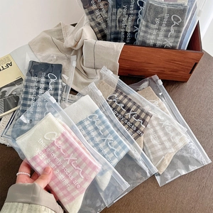 Detailed view of British plaid socks individually packed in premium matte zipper bags