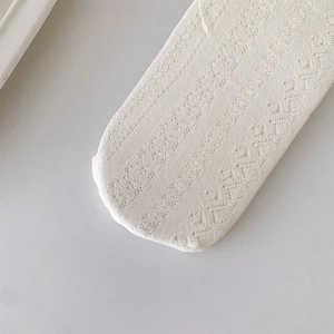 Close-up of white Lolita style socks showing intricate hollow knit mesh and lace texture