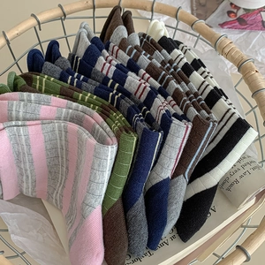 Detail of colorful striped cotton socks with ribbed cuffs neatly organized in a basket