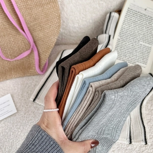 Détail de chaussettes en maille côtelée multicolores avec texture et bord roulé rétro