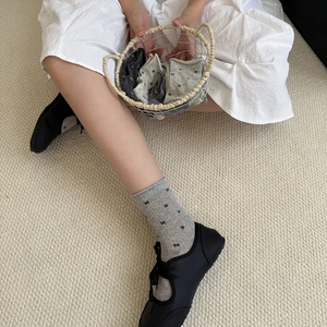 Detailed knit of grey cotton crew socks featuring cute black bow embroidery patterns