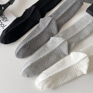 Detail of ribbed knit crew socks in black and grey tones with honeycomb texture