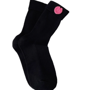 Black mid-calf ribbed knit socks with pink crochet heart detail on a white background