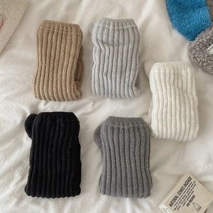 Macro detail of knit leg warmers in various colors showing thick ribbed texture