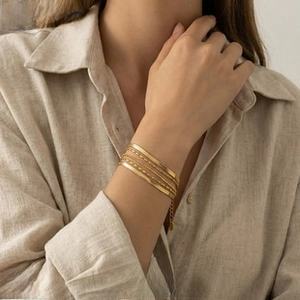 Close-up of gold oval hoop earrings worn by a model in a minimalist French vintage style