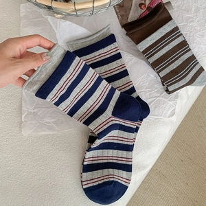 Detail shot of striped cotton mid-tube socks showing knit texture and ribbed elastic cuffs