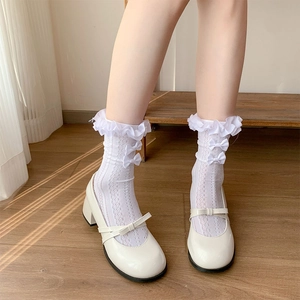 Detailed view of white lace mesh socks with bows and ivory Mary Jane platform shoes