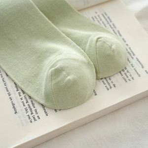 Macro detail of fine knit seams and light green fabric texture of these cotton socks
