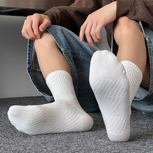 Detail view of white crew socks showing breathable mesh texture and diamond knit pattern