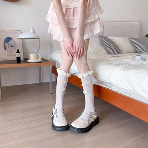 Detailed view of white lace Lolita socks with ribbon bows and Mary Jane platform shoes