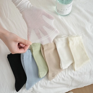 Close-up of thin breathable mid-calf socks in diverse pastel colors and sheer texture