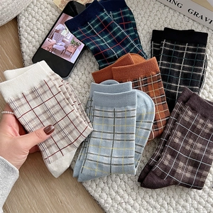 Flat lay of vintage plaid crew socks in multiple colors with cozy autumnal styling