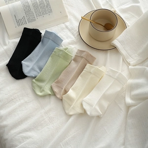 Flat lay of six pairs of colorful cotton mid-calf socks in soft pastel and neutral tones