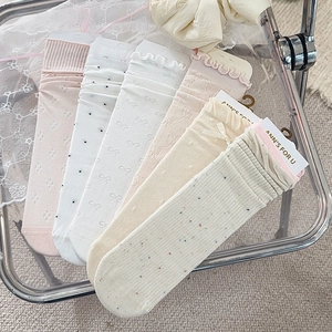 Detailset aus 6 Paar beigen und rosa Schleifensocken mit Punkten auf einem schicken Stuhl