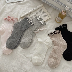Detail of six pastel cotton socks with frill cuffs and vertical ribbed knit texture