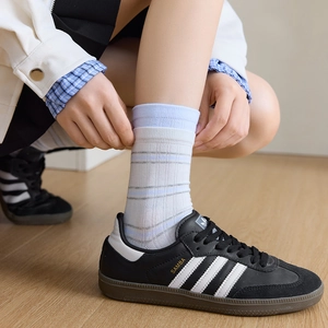 Detail of breathable striped cotton crew socks with ribbed cuffs and blue stripe pattern