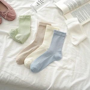 Flat lay of cotton mid-calf socks in cream pastel colors with ribbed cuffs and soft texture