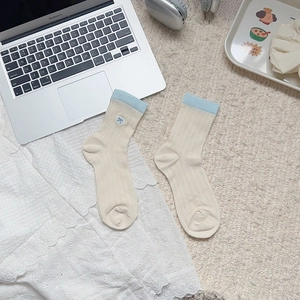 Detail of preppy style mid-calf socks with blue bow embroidery and lace trim