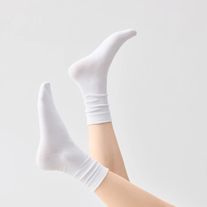 Close-up of white slouch socks featuring vertical ribbed texture and minimalist design