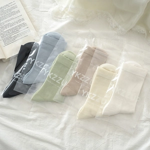 Detailed view of six pairs of pastel ankle socks in individual branded transparent packaging