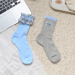 Détail de chaussettes à volants à carreaux bleus et chaussettes grises à nœud papillon