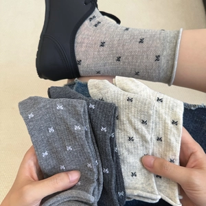 Detailed knit texture of breathable cotton socks featuring small black bow patterns