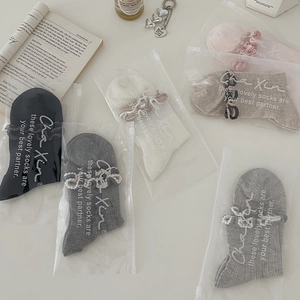 Flat lay of colorful breathable cotton socks with lace trim in branded zip packaging