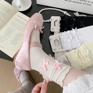 Detailed view of pink ballet flats with bow and white stockings featuring ribbon details
