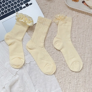 Three pairs of cream yellow ballet-style socks with lace ruffles and bow embroidery