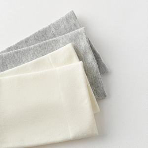 Detailed macro view of soft ribbed knit texture in grey and off-white cotton fabric