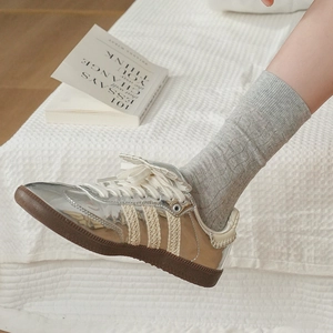 Dettaglio ravvicinato di scarpe retrò a righe e calze sottili in maglia a coste in posa relax