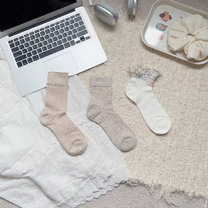Detail of three styles of college-style breathable cotton socks with lace and bow embroidery