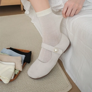 Detail of cream white mid-calf socks paired with pearl-buckle Mary Jane shoes