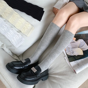 Detailed knit texture of slim-fit knee-high socks in versatile neutral colors